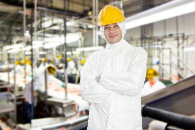 Industrial worker standing confidently in factory.