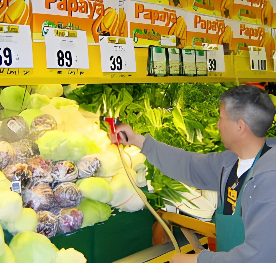 Man watering vegetables in supermarket