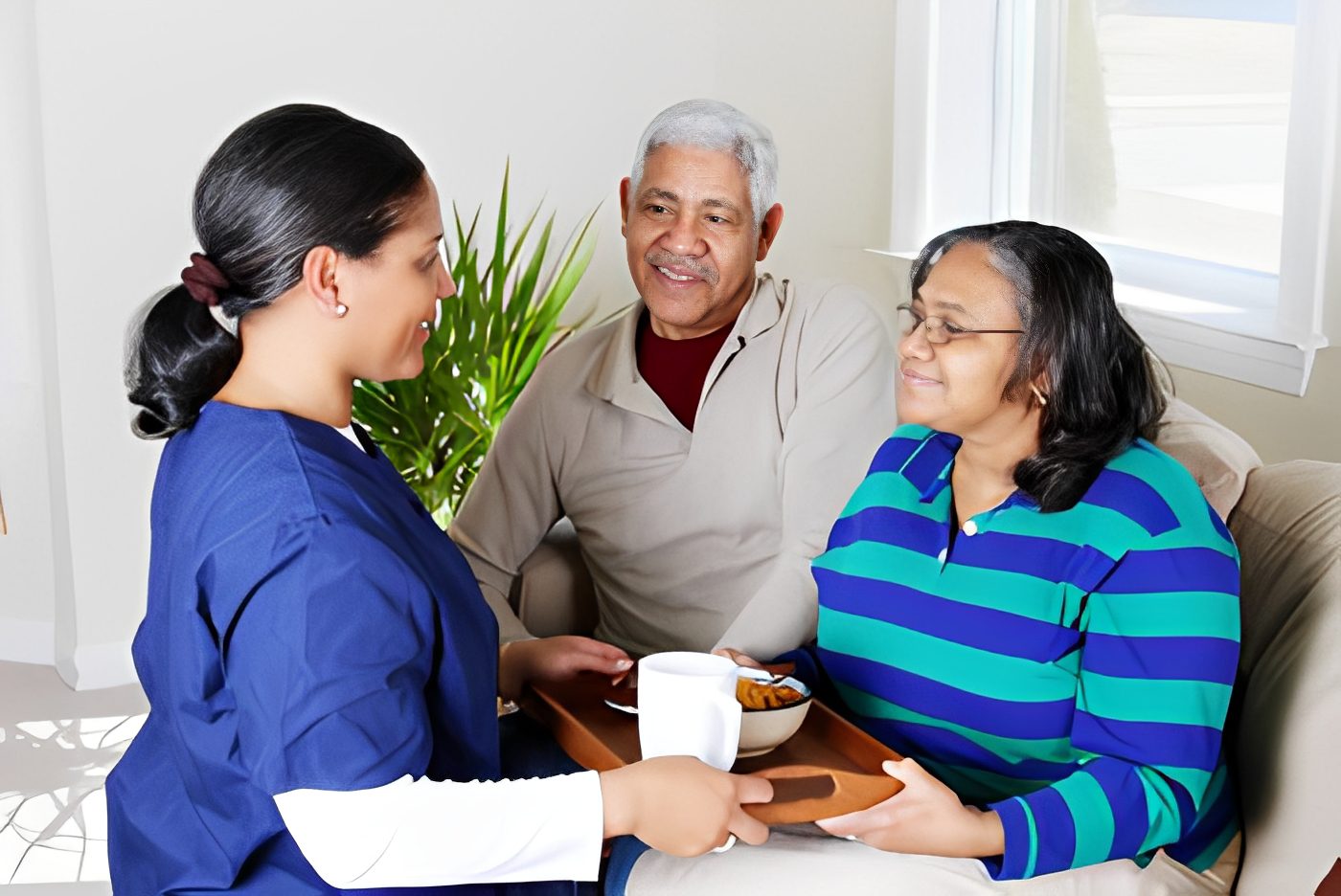 Nurse serving tea to elderly couple