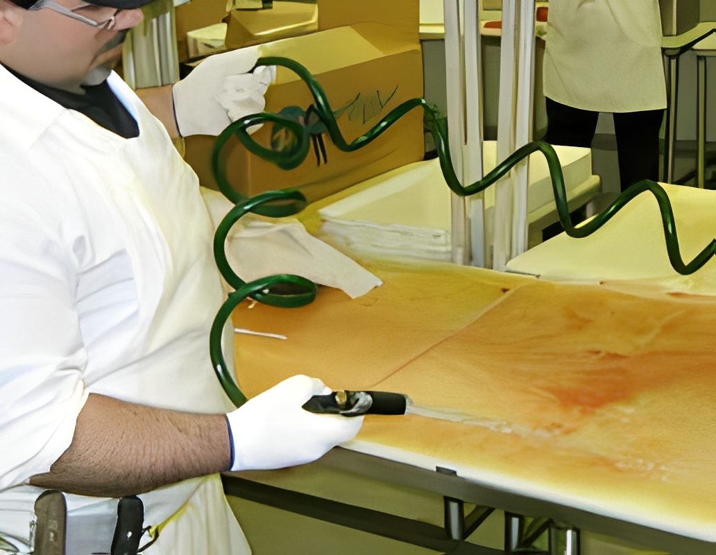 Person cleaning table with green hose